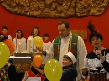Buntes Treiben herrschte während des Gottesdienstes um den Altar mit Pfarrer Mathias Rusin (Mitte) und Karin Kunzelmann (rechts) vom Team der Kinderkirche. Foto: may
