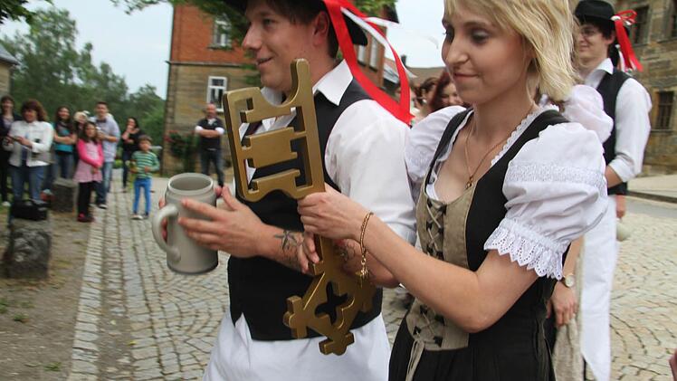 Bloß nicht warten, Volldampf voraus: Marina Ellner und Patrick Schott stürmen mit den anderen Ortsburschen und -madla die Linde: Peesten hat Kerwa. Foto: Sonja Adam
