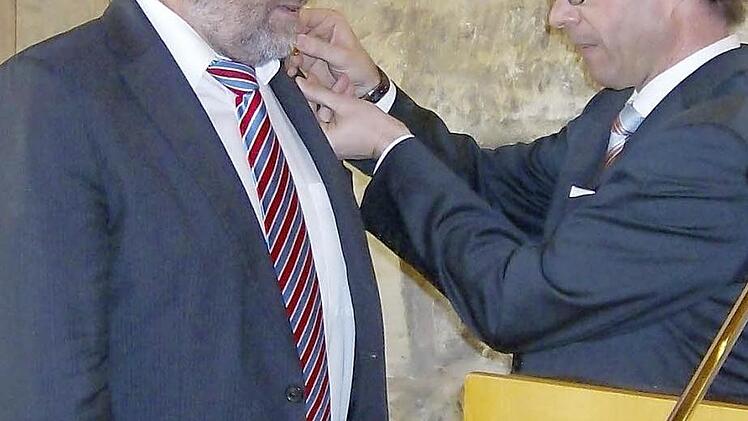 Jürgen Gros (r.) heftet dem Jubilar Wolfgang Holler die goldene Ehrennadel an.  Foto: Malbrich