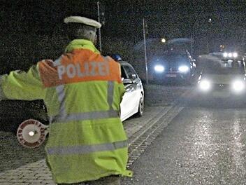 Tobias Kern, deutlich sichtbar mit Warnkleidung, hält ein Auto zur Kontrolle an. Die Beleuchtung des Pkw wird überprüft.  Fotos: Helmut Will