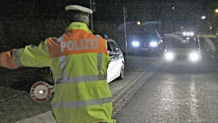 Tobias Kern, deutlich sichtbar mit Warnkleidung, hält ein Auto zur Kontrolle an. Die Beleuchtung des Pkw wird überprüft.  Fotos: Helmut Will