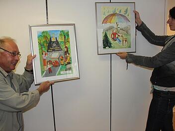 Erwin Koch und Carolin Schuler von der VHS nehmen Maß. Seit dem Mittwoch wird die Bilderausstellung aufgebaut.  Foto: Ralf Kestel