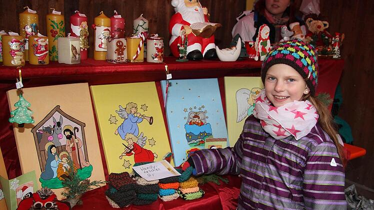 Selbstgemachtes gibt es am Stand der Ministranten: Auch Patricia hat eine Kerze verziert.