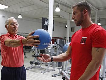 Horst Weckmüller leidet an ALS, da kann schon das Heben eines zwei Kilogramm schweren Balles zum Kraftakt werden. Norman Weckmüller hilft seinem Vater und hat für ihn ein Trainingsprogramm gegen den Muskel-Abbau erarbeitet. Foto:Roepert