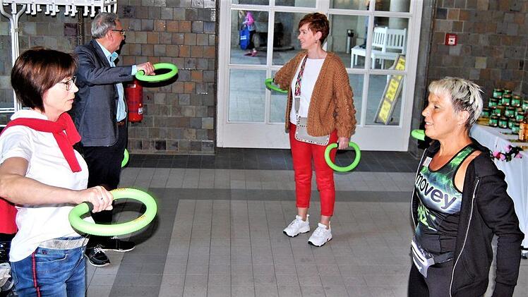 Einfache gesundheitsfördernde Angebote wurden gleich ausprobiert: Hier üben Petra Kachel (vorne rechts) und drei Besucher an Schwungringen. Foto: Sigismund von Dobschütz