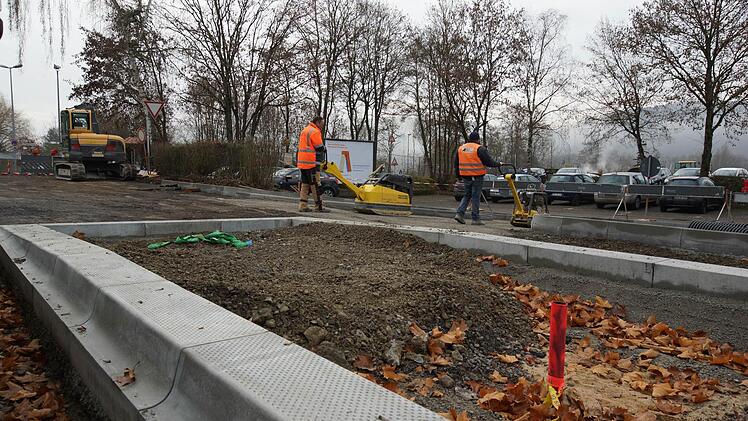 Arbeiter befestigen die neu angelegte Zufahrt zum Parkplatz Am Weihertorplatz. Foto: Arkadius Guzy