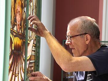 Peter Adrian von der Paderborner Spezial-Firma Glasmalerei Peters setzt Buntglasscheiben im Luitpoldbad ein. Foto: Benedikt Borst