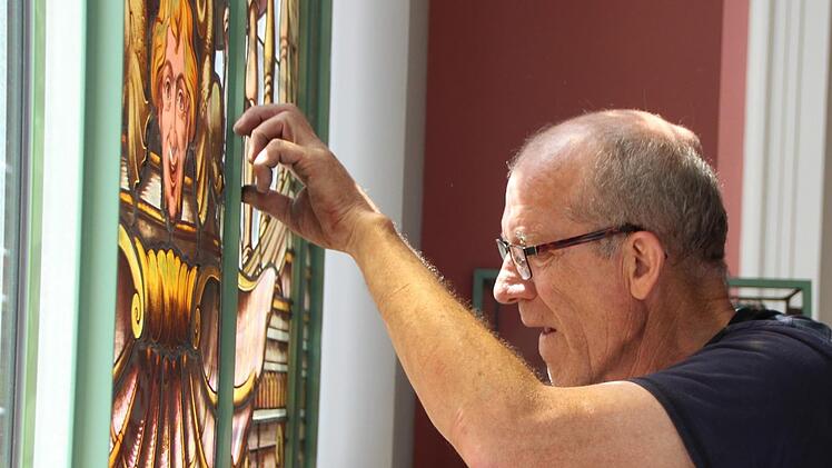Peter Adrian von der Paderborner Spezial-Firma Glasmalerei Peters setzt Buntglasscheiben im Luitpoldbad ein. Foto: Benedikt Borst