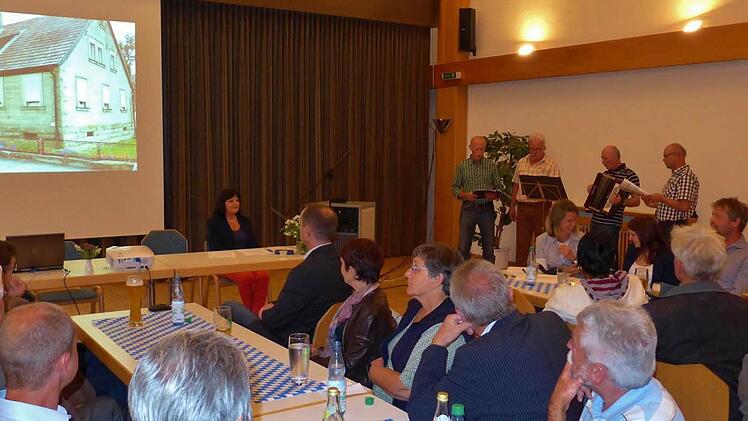 Die Köhlertaler Musikanten tragen Heimatlieder vor, während Teilnehmer der Informationsveranstaltung Sandstein an Häusern betrachteten. Foto: Sabine Meißner