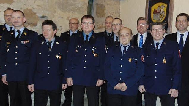 Landrat Ulm (r.) würdigt die verdienten Feuerwehrleute aus Neunkirchen.  Foto: Petra Malbrich