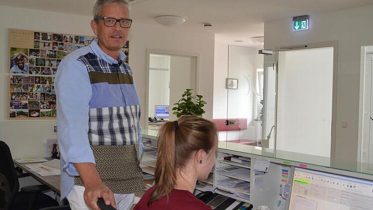 Allgemeinmediziner Stephan Stoll gibt bei seiner Sprechstundenhilfe, Martha Rösner, in der Gemeinschaftspraxis in Bad Bocklet, Rezepte und Verordnungen in Auftrag. Gleich hat er Mittagspause.  Foto: Kathrin Kupka-Hahn