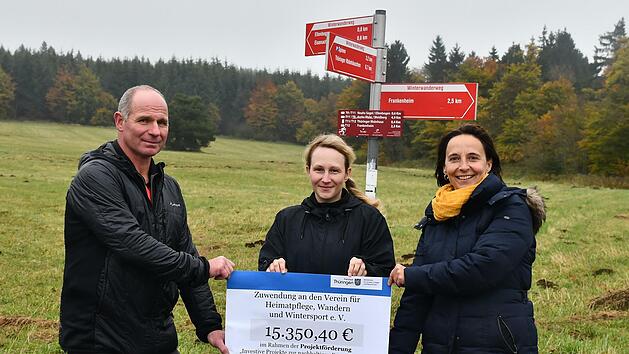 Ulrike Schade (rechts) und Nadja Th&uuml;rbeck von der Th&uuml;ringer Verwaltung des Unesco-Biosph&auml;renreservats Rh&ouml;n &uuml;bergaben den symbolischen Scheck an Heiko Fuchs vom Verein f&uuml;r Heimatpflege, Wandern und Wintersport Ellenbogen.
