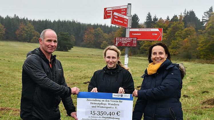 Ulrike Schade (rechts) und Nadja Thürbeck von der Thüringer Verwaltung des Unesco-Biosphärenreservats Rhön übergaben den symbolischen Scheck an Heiko Fuchs vom Verein für Heimatpflege, Wandern und Wintersport Ellenbogen.
