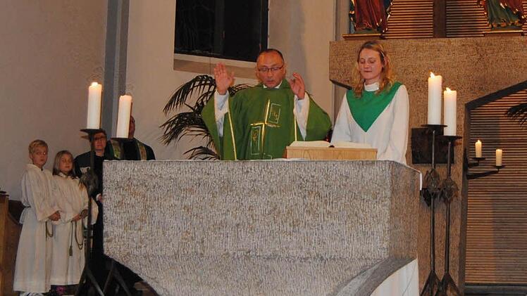 Karina Weiß mit Pfarrer Kidjemet beim Abschiedsgottesdienst am Altar