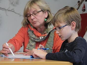 Die 58-jährige Diplom-Sozialpädagogin Maria Poglitsch hilft einem Schüler bei den Hausaufgaben im Fach Mathematik.  Foto: Sarah Stieranka