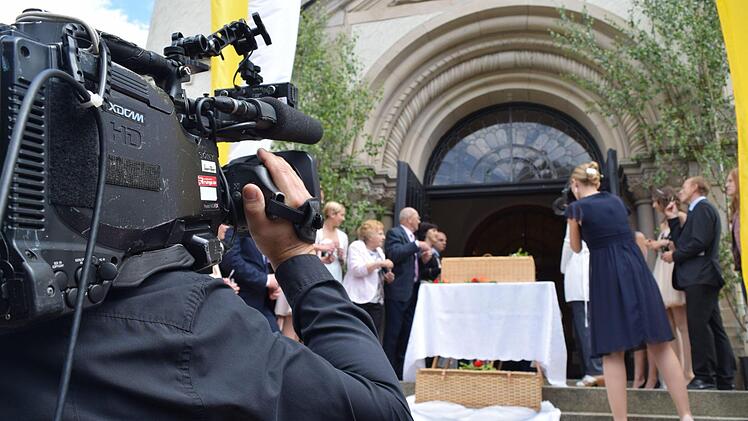 Die Aufnahme läuft schon, nur das Brautpaar fehlt noch: Die Gäste und das Kamerateam positionieren sich, bevor das frisch vermählte Paar vor die Kirche tritt. Foto: Daniela Pondelicek