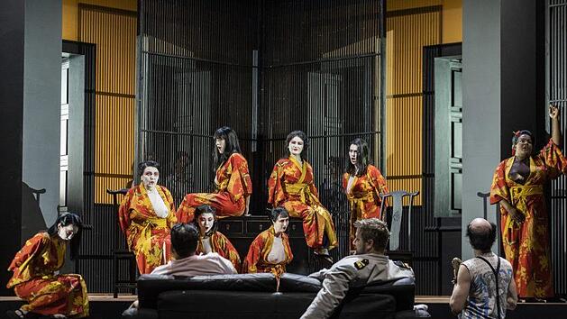 Hingefläzt aufs Sofa begutachten Konsul Sharpless (links  Sangmin Lee), B. F. Pinkerton (Tadeusz Szlenkier) und Goro (Hans Kittelmann) die Geishas Ludwig Olah