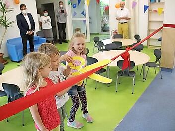 Beim Banddurchschneiden durften die Kinder die Erwachsenen unterstützen. Im Anschluss wurde im Garten gemeinsam gefeiert, es gab Bratwürste von der Metzgerei Köhler aus Untersiemau, selbstgebackenen Kuchen und vieles mehr.