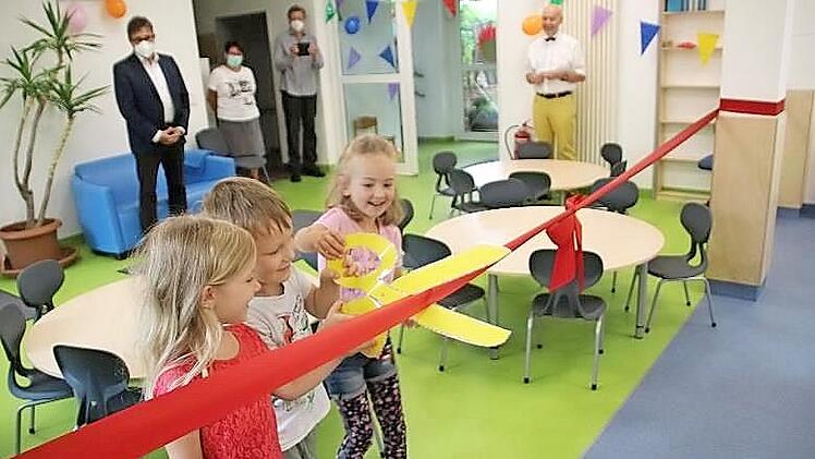 Beim Banddurchschneiden durften die Kinder die Erwachsenen unterstützen. Im Anschluss wurde im Garten gemeinsam gefeiert, es gab Bratwürste von der Metzgerei Köhler aus Untersiemau, selbstgebackenen Kuchen und vieles mehr.