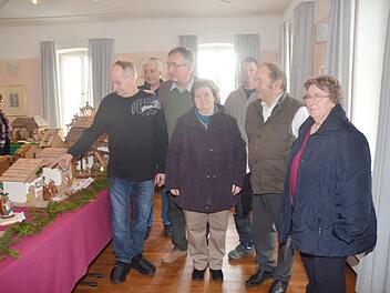 Die Eröffnung der ersten Krippenausstellung in Schmölz mit (vorne links) Initiator und Organisator Gerhard Schmidt, der durch die Ausstellung führte, Pfarrer Gerald Munzert (Dritter von links) mit einigen Ehrengästen. Foto: Karl-Heinz Hofmann
