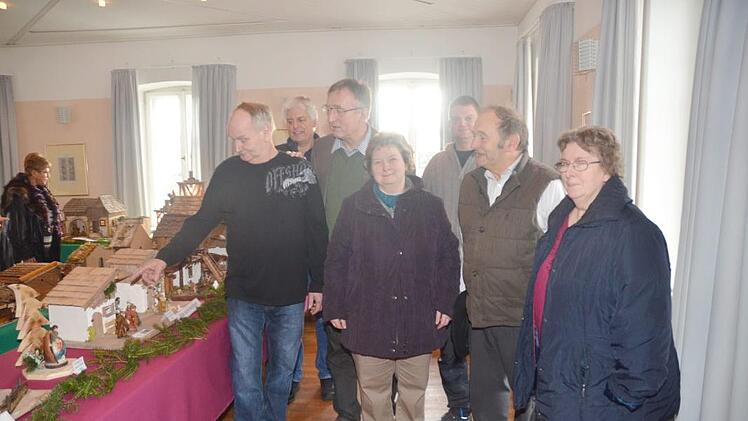 Die Eröffnung der ersten Krippenausstellung in Schmölz mit (vorne links) Initiator und Organisator Gerhard Schmidt, der durch die Ausstellung führte, Pfarrer Gerald Munzert (Dritter von links) mit einigen Ehrengästen. Foto: Karl-Heinz Hofmann