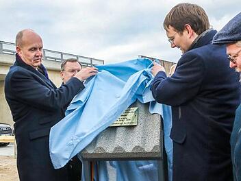 Gerhard Rühmkorf (Ministerialdirigent im Bundesministerium für Verkehr) und Hans Reichhart (Bayerischer Staatsminister für Wohnen, Bau und Verkehr) lüften das Musterstück der Lärmschutzwand zur Freigabe der A73 in Forchheim. Foto: Barbara Herbst