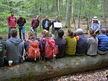 Forstbetriebsleiter Ulrich Mergner (mit Tafel) referiert im Naturwaldreservat, rechts der Professor der Studenten. Foto: Ronald Rinklef