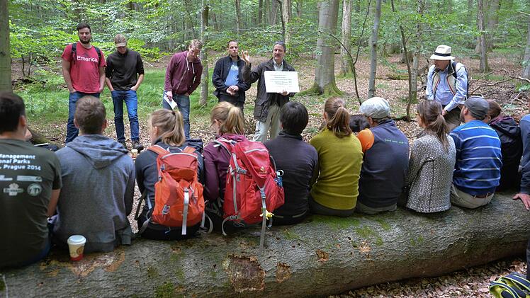 Forstbetriebsleiter Ulrich Mergner (mit Tafel) referiert im Naturwaldreservat, rechts der Professor der Studenten. Foto: Ronald Rinklef