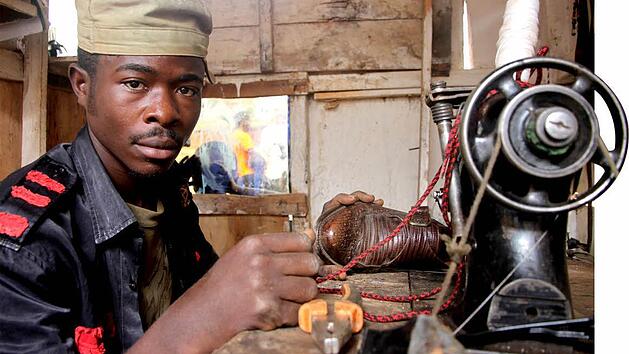 Der ehemalige Kindersoldat Patrice (Name ge&auml;ndert, 19) in seiner von WorldVision finanzierten Schusterwerkstatt in Butembo (Ostkongo). Foto: Philipp Hedemann