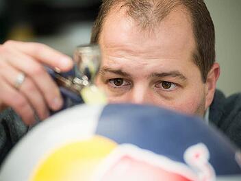 Markus Däumler lackiert einen Rallye-Helm. Auch Formel-1-Fahrer und Piloten lassen ihre Helme in Röslau gestalten.   Fotos: Tobias Köpplinger