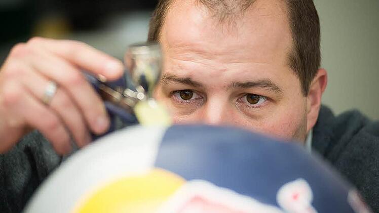 Markus Däumler lackiert einen Rallye-Helm. Auch Formel-1-Fahrer und Piloten lassen ihre Helme in Röslau gestalten.   Fotos: Tobias Köpplinger
