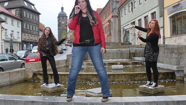Musikerinnen mit Sinn für Humor: Für ein Foto steigen Stefanie Hauber (links), Anna Rosenfeld und Jana Efremova (rechts) in den Floriansbrunnen und spielen Luftbass - oder Luftvioline. Foto: Markus Häggberg
