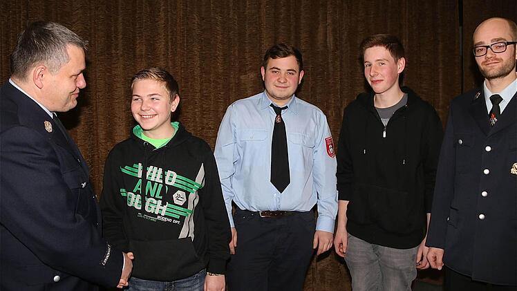 Per Handschlag nahm Kommandant Manfred Reith (von links) den Jugendlichen Fabian Fink in die Jugendfeuerwehr auf. Von dort aus rückten Niklas Appel und Dominik Müller als Aktive in die Reihen der Erwachsenenfeuerwehr auf, wozu auch Vorsitzender Christoph Joa gratulierte. Foto: Schaar