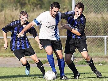 Die beiden Röbersdorfer Niklas Rittmaier (l.) und Bastian Walz (r.) nehmen den Walsdorfer Spielertrainer André Distler in die Zange. Fotos: sportpress