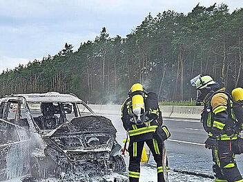 Feuerwehrleute der Freiwilligen Feuerwehr Höchstadt löschen ein brennendes Auto auf der A3.