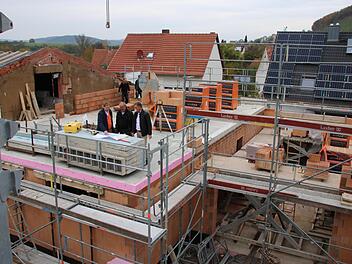 Vom Kran aus ist die Baustelle des neuen Feuerwehrhauses gut zu überblicken: links das Dach des bestehenden Schulungsraumes, dann Umkleiden und Büro sowie rechts der Stellplatz fürs Fahrzeug. In der Bildmitte studieren Stadtbaumeister Detlef Mohr,...