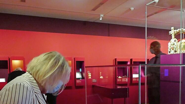 Blick in einen der Schaur&auml;ume, in dem eine Besucherin das Sakramentar Heinrichs&nbsp;II. betrachtet. Dar&uuml;ber eine Nachbildung der Reichskrone.  Fotos: Kr&uuml;ger-Hundrup