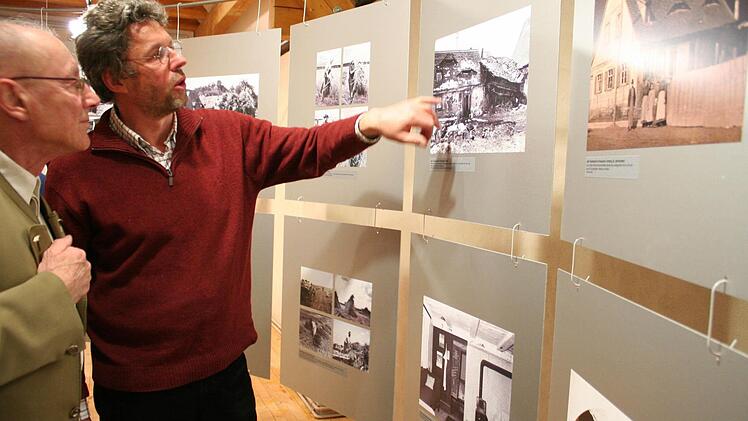 Zwei Ausstellungsbesucher im Gespräch über den verfallenen Fischerhof, heute Bauernmuseum des Landkreises. Foto: Evi Seeger