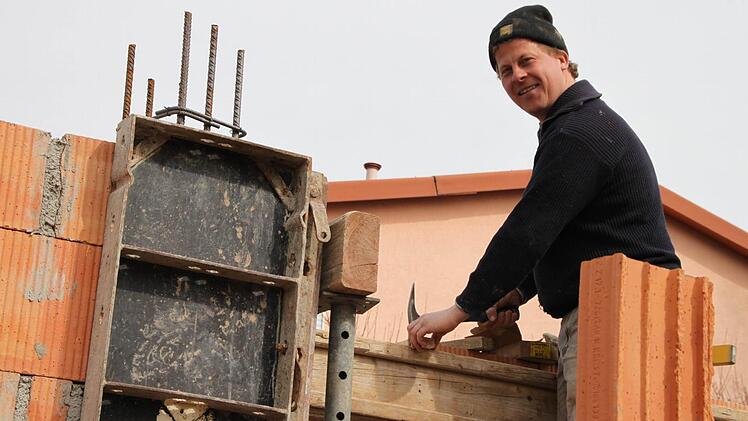 Er ist gerade dabei, Nägel einzuschlagen.