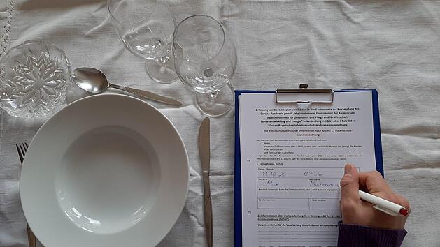 Die Kontaktdaten seiner Gäste muss ein bayerischer Gastronom für vier Wochen nach dessen Besuch aufbewahren. Wer falsche Kontaktdaten im Restaurant oder Gasthof hinterlässt, muss ab sofort eine Geldstrafe zahlen. Foto: Corinna Tübel