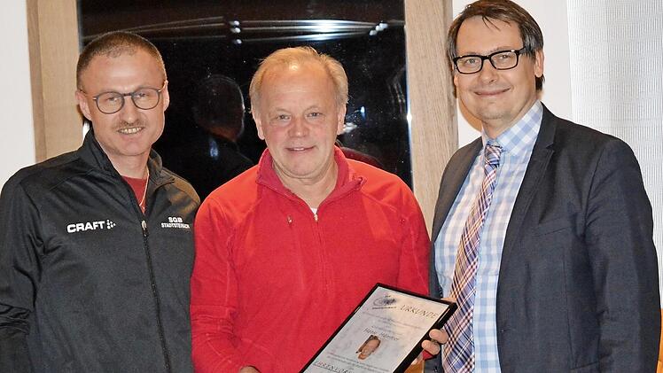 Vorsitzender Harald Schricker (links) und Bürgermeister Roland Wolfrum (rechts) überreichen Hansi Hümmer die Ernennungsurkunde zum Ehrenvorsitzenden.  Foto: Dieter Hübner