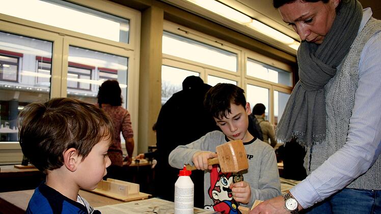 Drittkl&auml;ssler Ben (Mitte) hilft Theodor und seiner Mutter beim Bau eines Boots im Werkraum der Montessori-Schule.