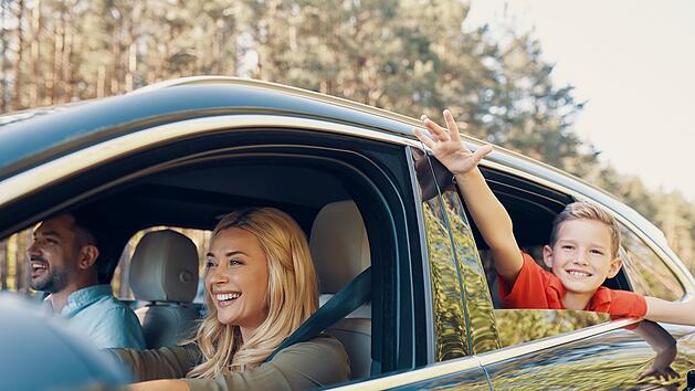 Young beautiful family with little boy having fun and smiling while driving in the car, Urlaub