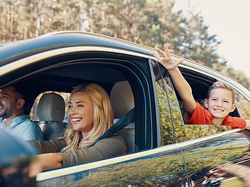 Young beautiful family with little boy having fun and smiling while driving in the car, Urlaub