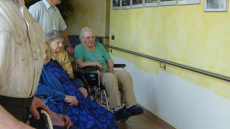 Manfred Mösch und einige Mitbewohner im Seniorendorf Kirschenallee in Thurnau betrachten sich die Ausstellung "Thurnau gestern und heute".
