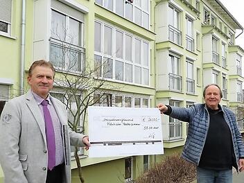 Rotary-Präsident Ludwig Weiß (links) übergibt einen symbolischen Scheck an Theaterintendant Jan Burdisnki.