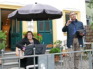 Professor Stefan Hörmann dirigiert den Chor von seinem Vorgarten aus. Seine Frau spielt Gitarre.  Fotos: Marion Krüger-Hundrup