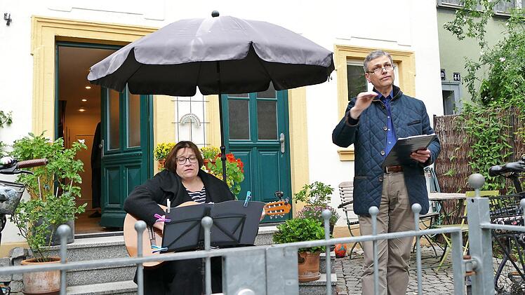 Professor Stefan Hörmann dirigiert den Chor von seinem Vorgarten aus. Seine Frau spielt Gitarre.  Fotos: Marion Krüger-Hundrup