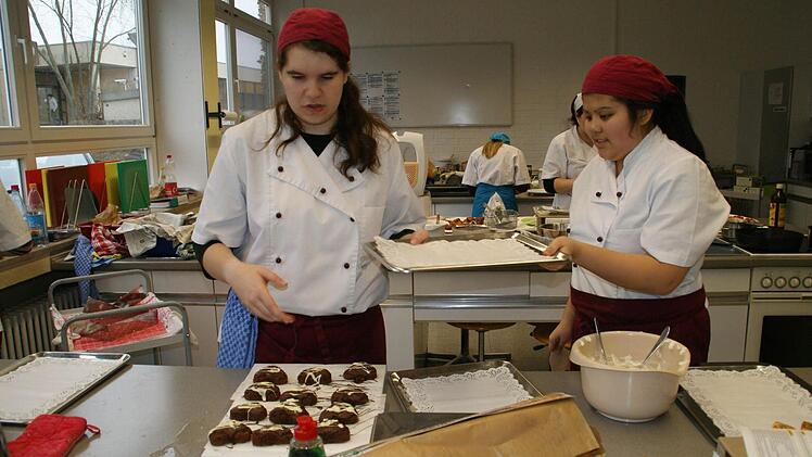 Hand in Hand arbeiten Sandra Lenhart (rechts) und Liane Krines. Schön gelungen sind die Schoko-Herzen; jetzt müssen sie ansprechend auf das Tablett arrangiert werden. Foto: Sabine Weinbeer