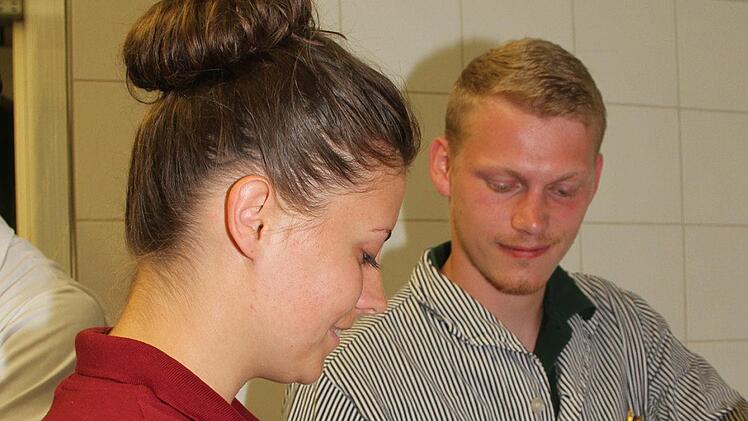 Stefan Kr&auml;uter reicht Liane G&ouml;rzen ein Wiener W&uuml;rstchen  ohne Saitling - es   steckt in einer Collagenh&uuml;lle. Foto: Sonny Adam